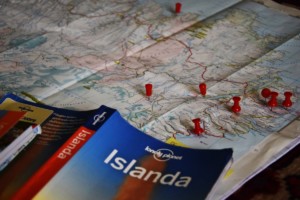 Fotografia scattata da The Half Hermit in fase di definizione dell'itinerario di #destinationIceland: la copertina della guida Lonely Planet e una carta dell'Islanda con le puntine nei luoghi che vuole visitare.
