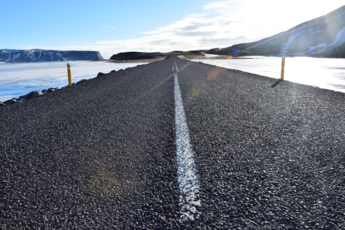 Fotografia scattata da The Half Hermit con inquadratura filo terra della strada che conduce a Dyrhólaey, promontorio sulla costa meridionale dell'Islanda. L'immagine rappresenta il motto di The Half Hermit "Il mio luogo è il movimento".